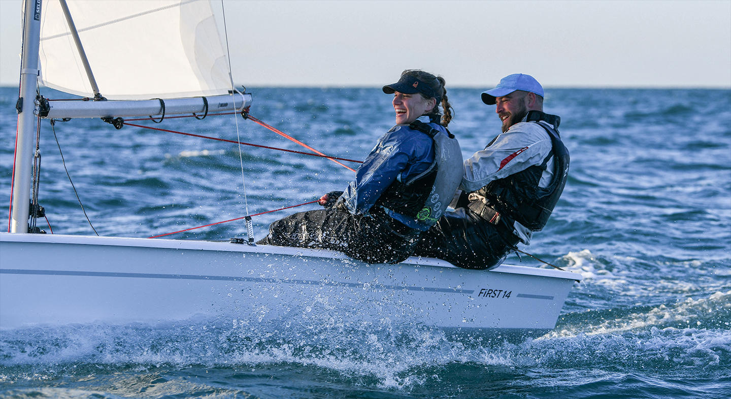 two people sailing on a first 14